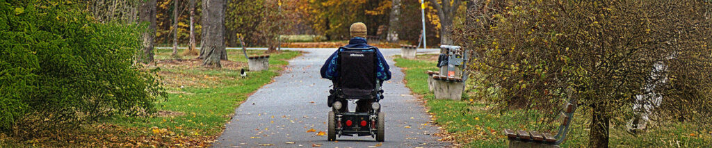 Sie sehen einen Rollstuhlfahrer der an Multiple Sklerose (MS) erkrankt ist. Multiple Sklerose (MS) ist eine chronisch-entzündliche ZNS-Erkrankung, die sich durch vielfältige neurologische Symptome äußert. Der Krankheitsbegriff leitet sich aus dem Lateinischen multiplex („vielfach“) und dem Griechischen skleros („trocken, hart“) ab. Charakteristisch für die Erkrankung sind entzündliche Prozesse im zentralen Nervensystem, die zu ZNS-Entzündungen führen und nach deren Abheilung Narben hinterlassen. Diese Myelinscheidenzerstörungbeeinträchtigt die Reizweiterleitung der Nerven, was zu einer vorübergehenden oder dauerhaften Störung der Informationsübertragung im Nervensystem führt.